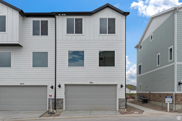 1889 E Thunder Ln Unit 496, Eagle Mountain, UT 84005 - view of front facade featuring board and batten siding, stone siding, an attached garage, central AC, and concrete driveway