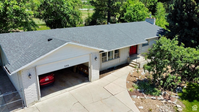 246 N 2800 E, Layton, UT 84040 - view of front of house featuring roof with shingles, driveway, a garage, and a chimney