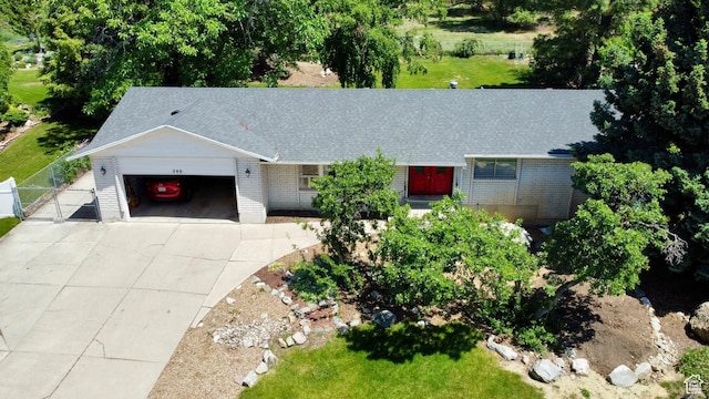 246 N 2800 E, Layton, UT 84040 - view of front facade with an attached garage, a gate, concrete driveway, brick siding, and roof with shingles