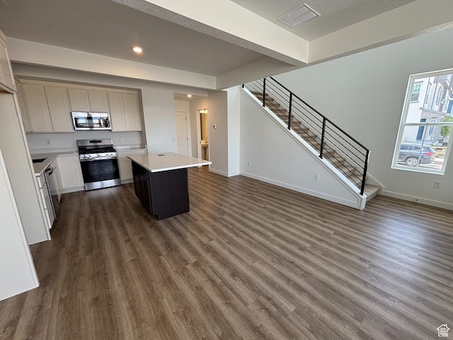 6907 W S Jordan Pkwy, South Jordan, UT 84009 - kitchen featuring appliances with stainless steel finishes, light countertops, dark wood finished floors, a kitchen island, and baseboards