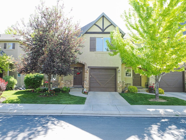 7183 S 420 E, Midvale, UT 84047 - view of front of home with stucco siding, a front yard, driveway, and stone siding