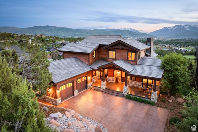 2314 E Flattop Mountain Dr Unit 89, Heber City, UT 84032 - view of front of property with a porch, stone siding, an attached garage, driveway, and a mountain view