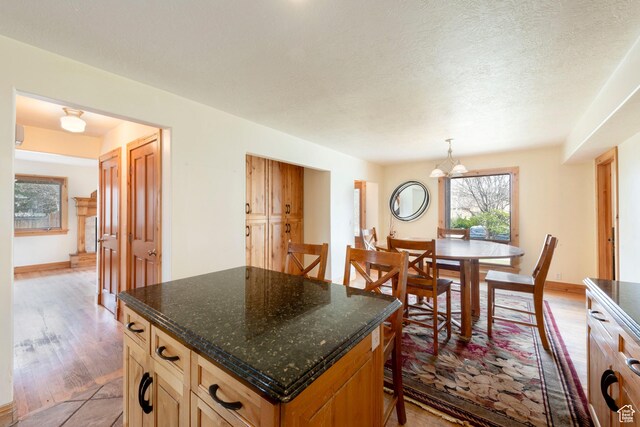 2003 Venus Ct, Park City, UT 84060 - kitchen featuring light wood-style flooring, a chandelier, a center island, hanging light fixtures, and dark stone counters