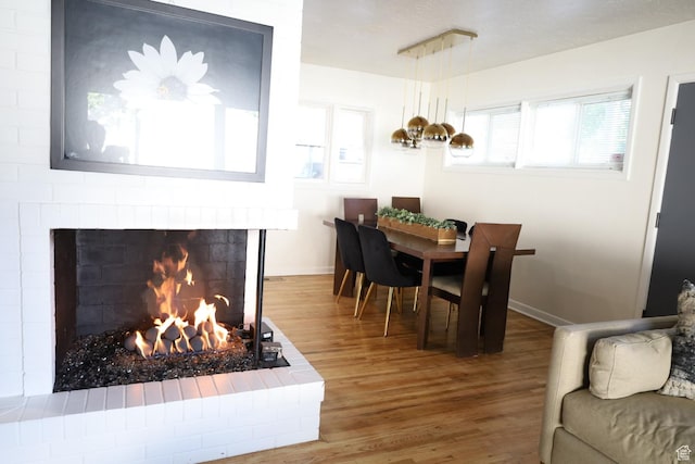 1834 E Cloverdale Rd S, Cottonwood Heights, UT 84121 - dining room with wood finished floors, a brick fireplace, and baseboards