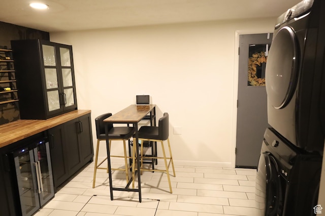 1834 E Cloverdale Rd S, Cottonwood Heights, UT 84121 - dining space with wine cooler, stacked washer / drying machine, recessed lighting, baseboards, and light tile patterned floors