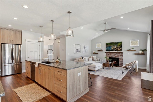 3222 W Harvard Dr, Mountain Green, UT 84050 - kitchen with stainless steel appliances, light brown cabinets, dark stone countertops, a center island with sink, and dark wood-style flooring