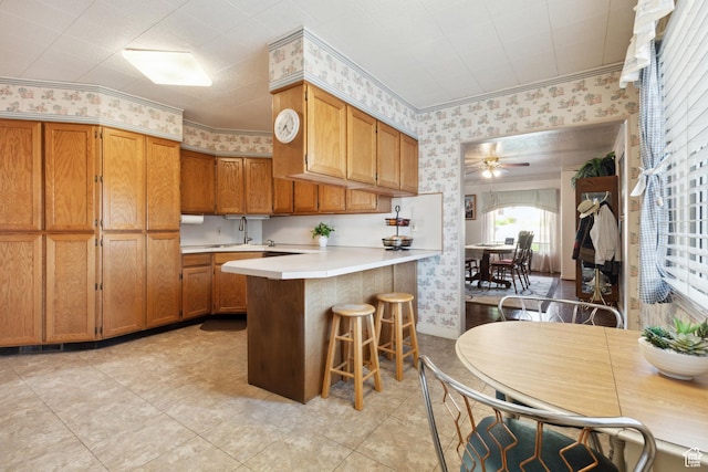 1095 N 100 W, Pleasant Grove, UT 84062 - kitchen with wallpapered walls, a peninsula, light countertops, brown cabinets, and ceiling fan