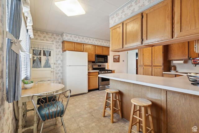 1095 N 100 W, Pleasant Grove, UT 84062 - kitchen with freestanding refrigerator, black microwave, stainless steel gas range, wallpapered walls, and light countertops