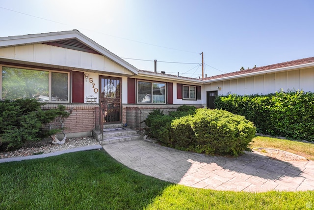 570 N Parkway Ave, Tooele, UT 84074 - single story home with board and batten siding, brick siding, and a front lawn