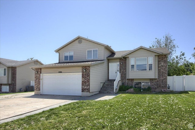 2086 S 50 E, Clearfield, UT 84015 - tri-level home featuring brick siding, concrete driveway, an attached garage, and central AC