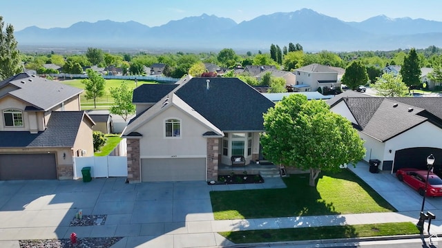 14263 S Morning Light Dr W, Herriman, UT 84065 - view of front of property with stucco siding, an attached garage, a mountain view, and driveway