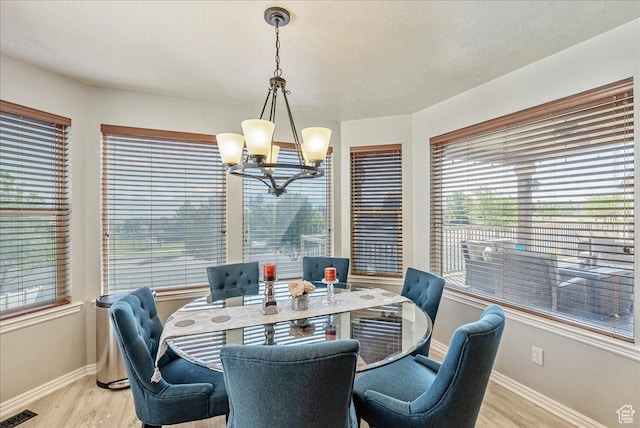14263 S Morning Light Dr W, Herriman, UT 84065 - dining area featuring a chandelier, baseboards, light wood finished floors, and healthy amount of natural light