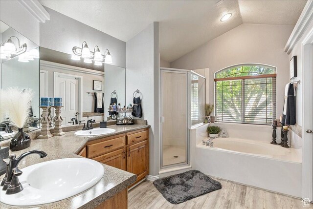 14263 S Morning Light Dr W, Herriman, UT 84065 - bathroom featuring a bath, vaulted ceiling, a shower stall, double vanity, and wood finished floors