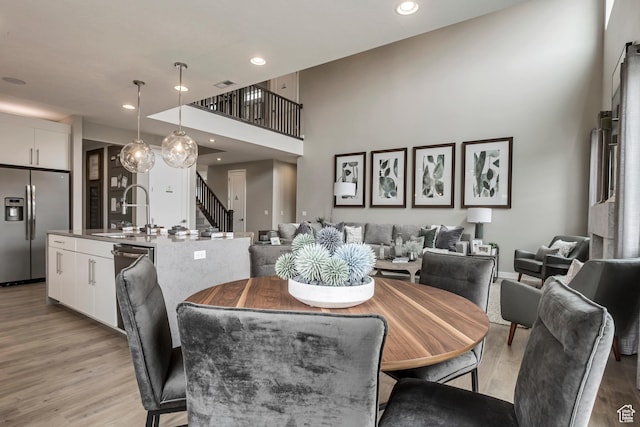 873 S 120 W Unit 003, American Fork, UT 84003 - dining space with light wood-type flooring, stairway, recessed lighting, and a high ceiling
