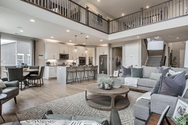 873 S 120 W Unit 003, American Fork, UT 84003 - living room with light wood-type flooring, a high ceiling, stairs, and recessed lighting