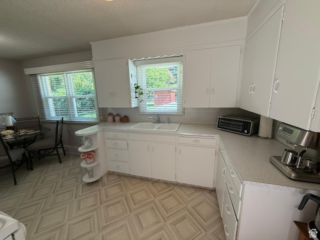 272 E 3000 N, North Ogden, UT 84414 - kitchen featuring a sink, light countertops, white cabinets, light flooring, and a textured ceiling