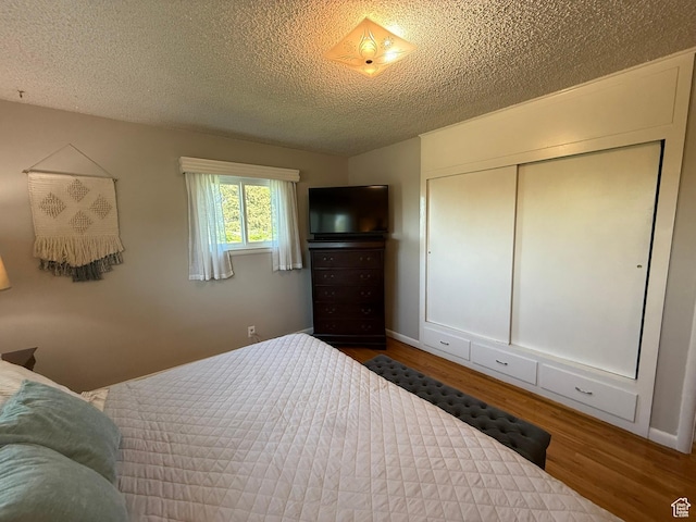 272 E 3000 N, North Ogden, UT 84414 - bedroom featuring wood finished floors, a textured ceiling, a closet, and baseboards