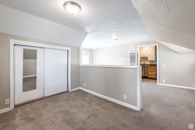 2269 S Green St Unit 1-4, Salt Lake City, UT 84106 - unfurnished bedroom with carpet floors, vaulted ceiling, a textured ceiling, baseboards, and a closet