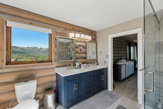 6380 N Silver Sage Dr, Park City, UT 84098 - bathroom featuring rustic walls, double vanity, a stall shower, toilet, and wood finished floors