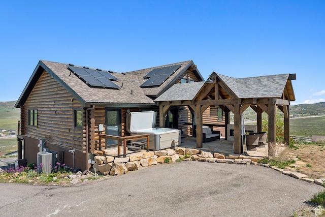 6380 N Silver Sage Dr, Park City, UT 84098 - view of front facade featuring a shingled roof, log exterior, solar panels, and a patio