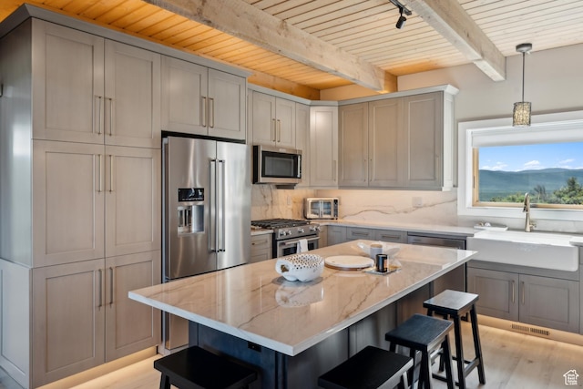 6380 N Silver Sage Dr, Park City, UT 84098 - kitchen featuring premium appliances, wood ceiling with exposed beams, a sink, a kitchen bar, and light stone counters