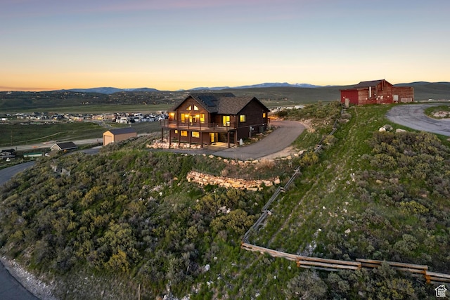 6380 N Silver Sage Dr, Park City, UT 84098 - back of house at dusk featuring a deck with mountain view, an outdoor structure, and a barn
