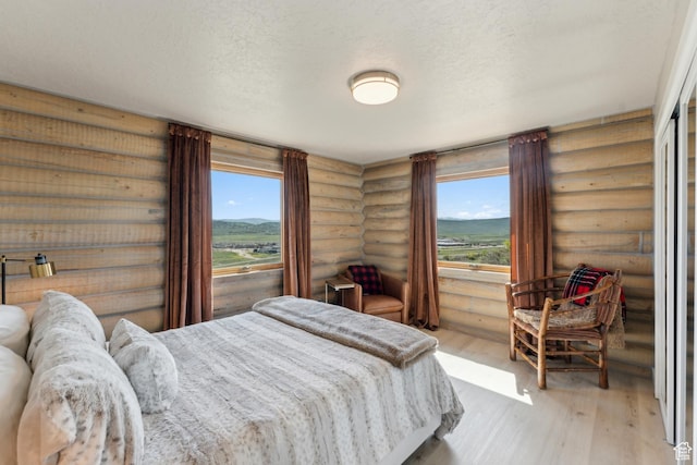 6380 N Silver Sage Dr, Park City, UT 84098 - bedroom with rustic walls, wood finished floors, and a textured ceiling