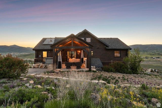 6380 N Silver Sage Dr, Park City, UT 84098 - cabin featuring an outdoor living space, log siding, roof mounted solar panels, and roof with shingles
