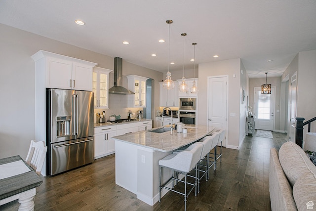 5028 W Lake Terrace Ave, South Jordan, UT 84009 - kitchen with stainless steel appliances, wall chimney range hood, a sink, a center island with sink, and a kitchen bar