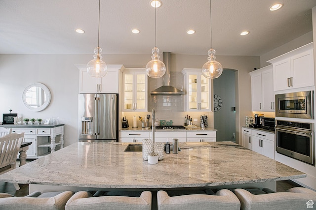 5028 W Lake Terrace Ave, South Jordan, UT 84009 - kitchen featuring stainless steel appliances, wall chimney range hood, a kitchen breakfast bar, recessed lighting, and glass insert cabinets