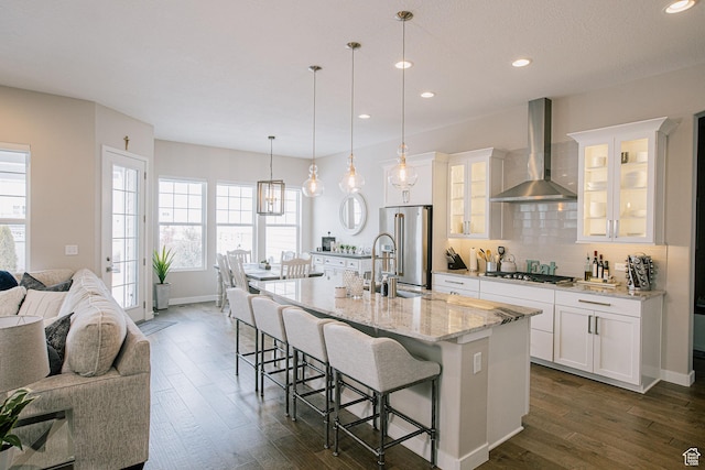 5028 W Lake Terrace Ave, South Jordan, UT 84009 - kitchen featuring wall chimney range hood, a sink, appliances with stainless steel finishes, open floor plan, and a kitchen bar