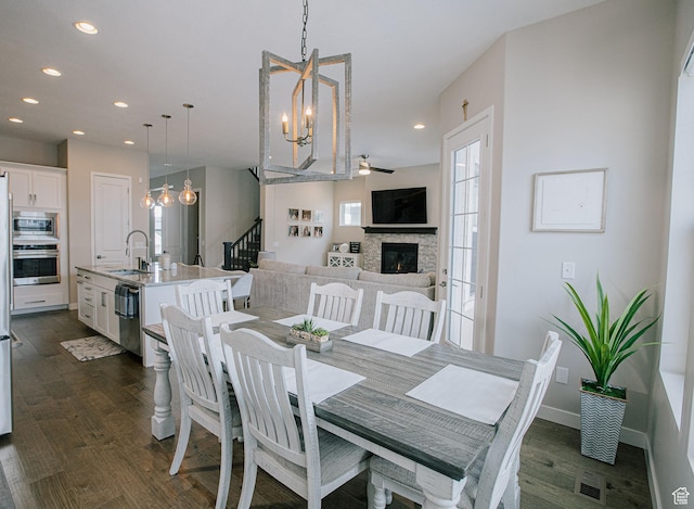 5028 W Lake Terrace Ave, South Jordan, UT 84009 - dining space featuring a chandelier, dark wood-style flooring, recessed lighting, a fireplace, and healthy amount of natural light