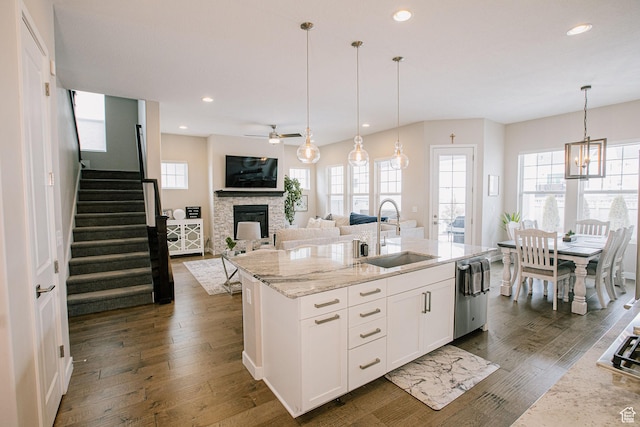 5028 W Lake Terrace Ave, South Jordan, UT 84009 - kitchen featuring a sink, a fireplace, dark wood-style flooring, light stone counters, and white cabinets