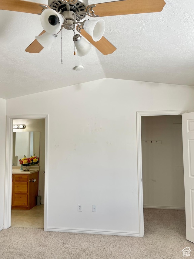 652 W 800 N Unit 112, Clinton, UT 84015 - unfurnished bedroom with light carpet, a walk in closet, ensuite bathroom, vaulted ceiling, and a ceiling fan