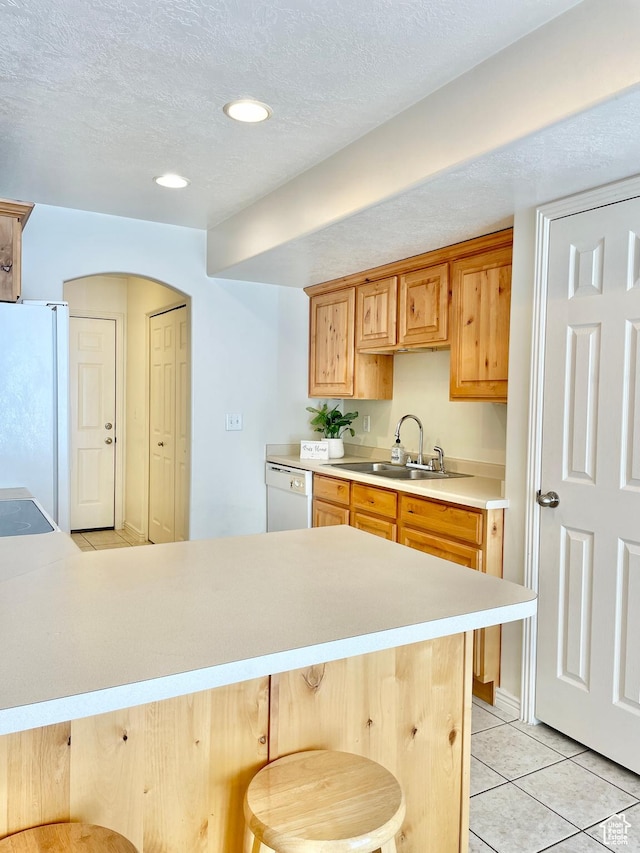 652 W 800 N Unit 112, Clinton, UT 84015 - kitchen featuring white appliances, light countertops, light tile patterned floors, a breakfast bar area, and arched walkways