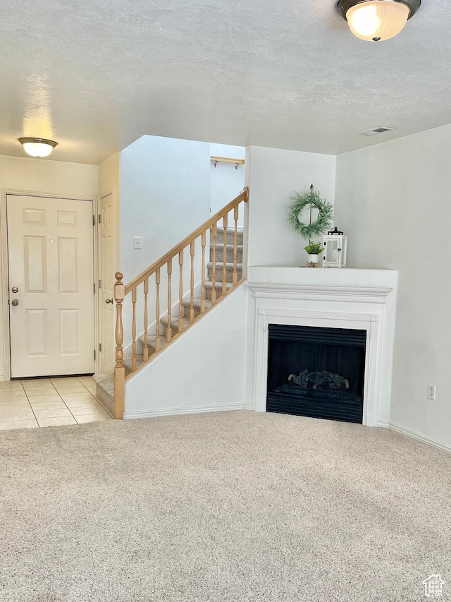 652 W 800 N Unit 112, Clinton, UT 84015 - unfurnished living room with carpet, a textured ceiling, stairs, a fireplace, and baseboards