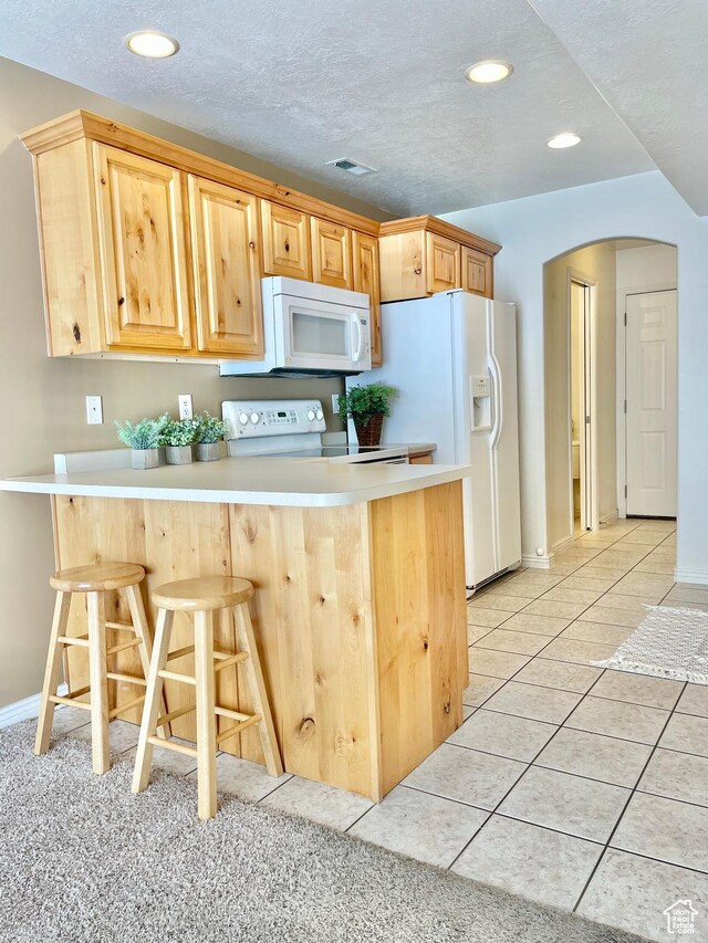 652 W 800 N Unit 112, Clinton, UT 84015 - kitchen featuring white appliances, arched walkways, a peninsula, a breakfast bar area, and recessed lighting