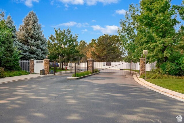 274 E Park Knoll Cir, Sandy, UT 84070 - view of asphalt road with a gate, a gated entry, and curbs