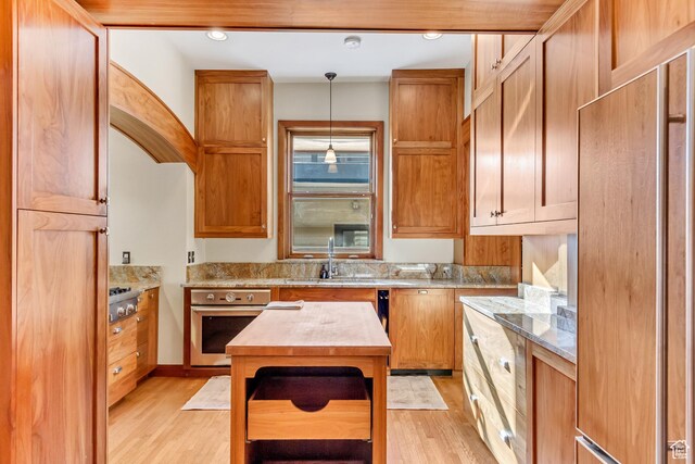 15 S 1200 E, Salt Lake City, UT 84102 - kitchen with stainless steel appliances, light wood finished floors, hanging light fixtures, and a sink