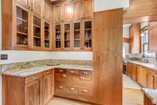 15 S 1200 E, Salt Lake City, UT 84102 - kitchen with a sink, light wood finished floors, light stone countertops, glass insert cabinets, and stainless steel oven