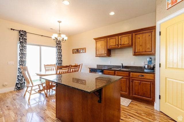 691 N 240 E Unit 39, Smithfield, UT 84335 - kitchen featuring a sink, a chandelier, brown cabinetry, light wood finished floors, and a kitchen island