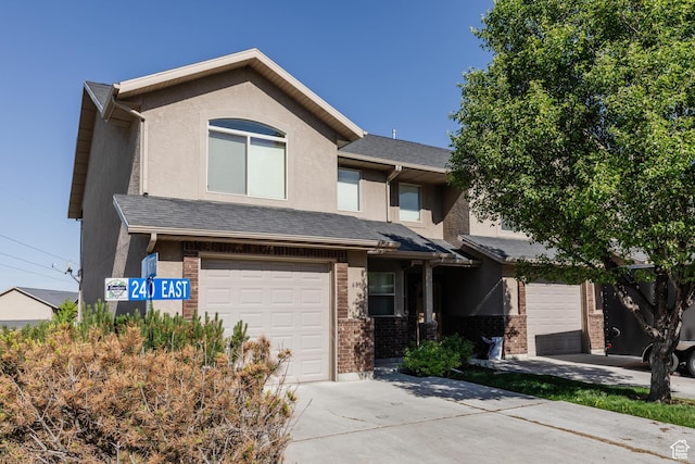 691 N 240 E Unit 39, Smithfield, UT 84335 - view of front of home with concrete driveway, brick siding, a garage, and stucco siding