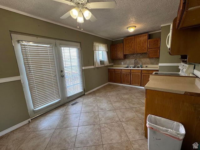 635 N Chimesview Cir E, Tooele, UT 84074 - kitchen featuring stove, brown cabinets, a sink, a textured ceiling, and light countertops