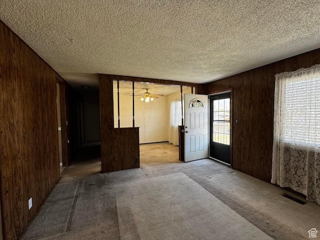 635 N Chimesview Cir E, Tooele, UT 84074 - entrance foyer featuring wooden walls, carpet flooring, a textured ceiling, and a ceiling fan