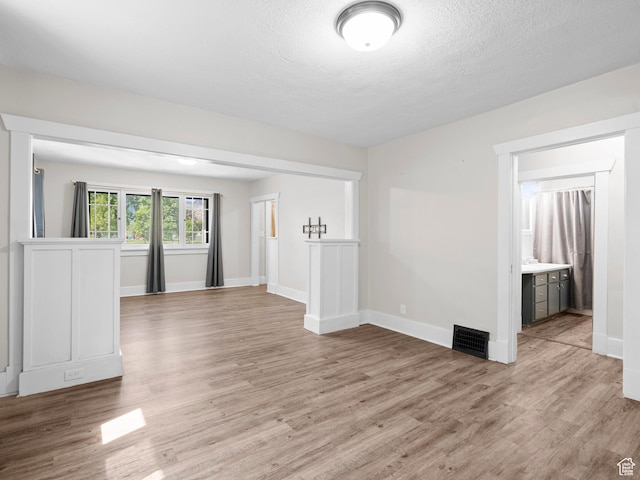 719 E 22nd St, Ogden, UT 84401 - unfurnished living room with light wood-style floors, baseboards, and a textured ceiling