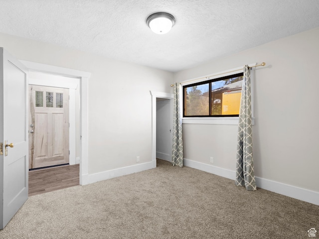 719 E 22nd St, Ogden, UT 84401 - unfurnished bedroom with carpet floors, a textured ceiling, and baseboards