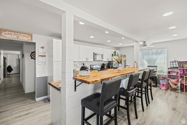 1725 N State St, Sigurd, UT 84657 - kitchen with stainless steel microwave, wood counters, electric range, a kitchen bar, and recessed lighting