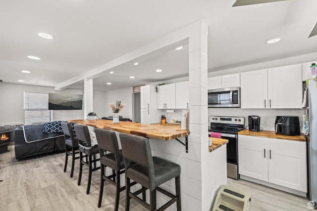 1725 N State St, Sigurd, UT 84657 - kitchen with wooden counters, stainless steel appliances, ornate columns, recessed lighting, and white cabinets