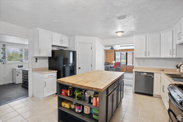 2137 W 6200 S, Salt Lake City, UT 84129 - kitchen with appliances with stainless steel finishes, white cabinetry, butcher block countertops, light tile patterned floors, and a textured ceiling