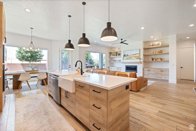 3322 S 2240 E, St George, UT 84790 - kitchen featuring dishwasher, a sink, recessed lighting, an island with sink, and a glass covered fireplace
